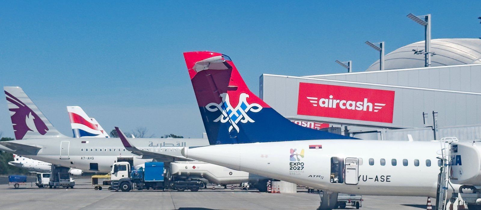Un avion ATR 72-600 al companiei Air Serbia pe platforma unui aeroport, cu coada roșu și albastră