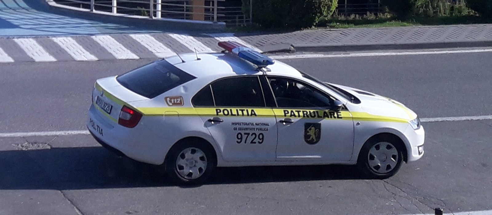 Mașină albă a Poliției de Patrulare cu dungă galbenă, pe o stradă din Chișinău