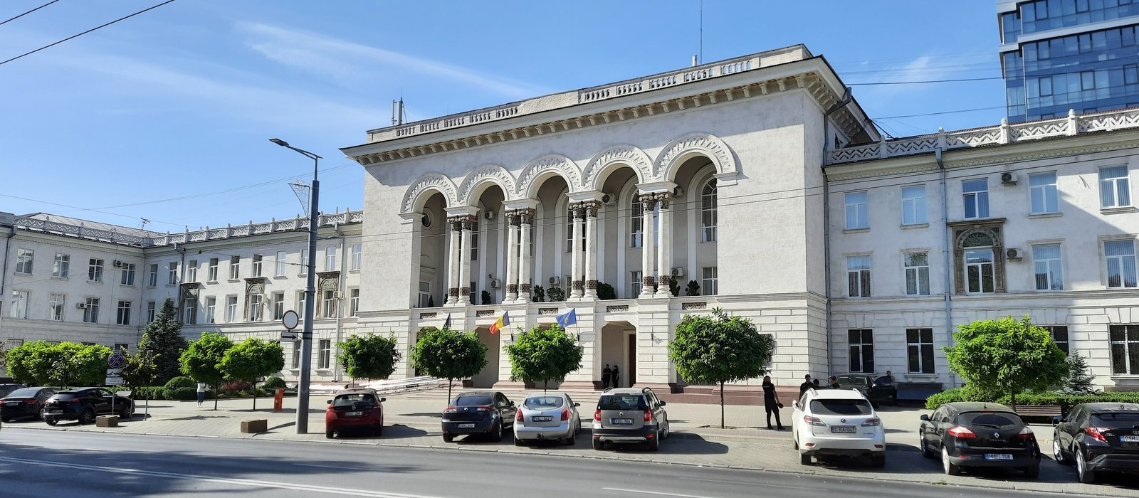 Clădirea Procuraturii Generale din Chișinău, cu fațadă albă, coloane, steagurile Republicii Moldova și Uniunii Europene