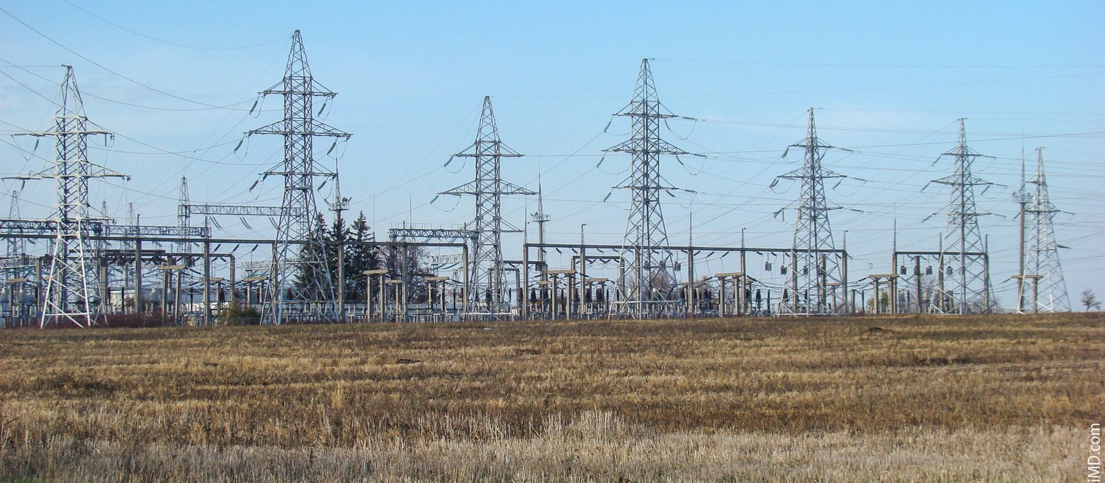 Stâlpi și linii de înaltă tensiune ale rețelei electrice din Republica Moldova, pe un cer luminos