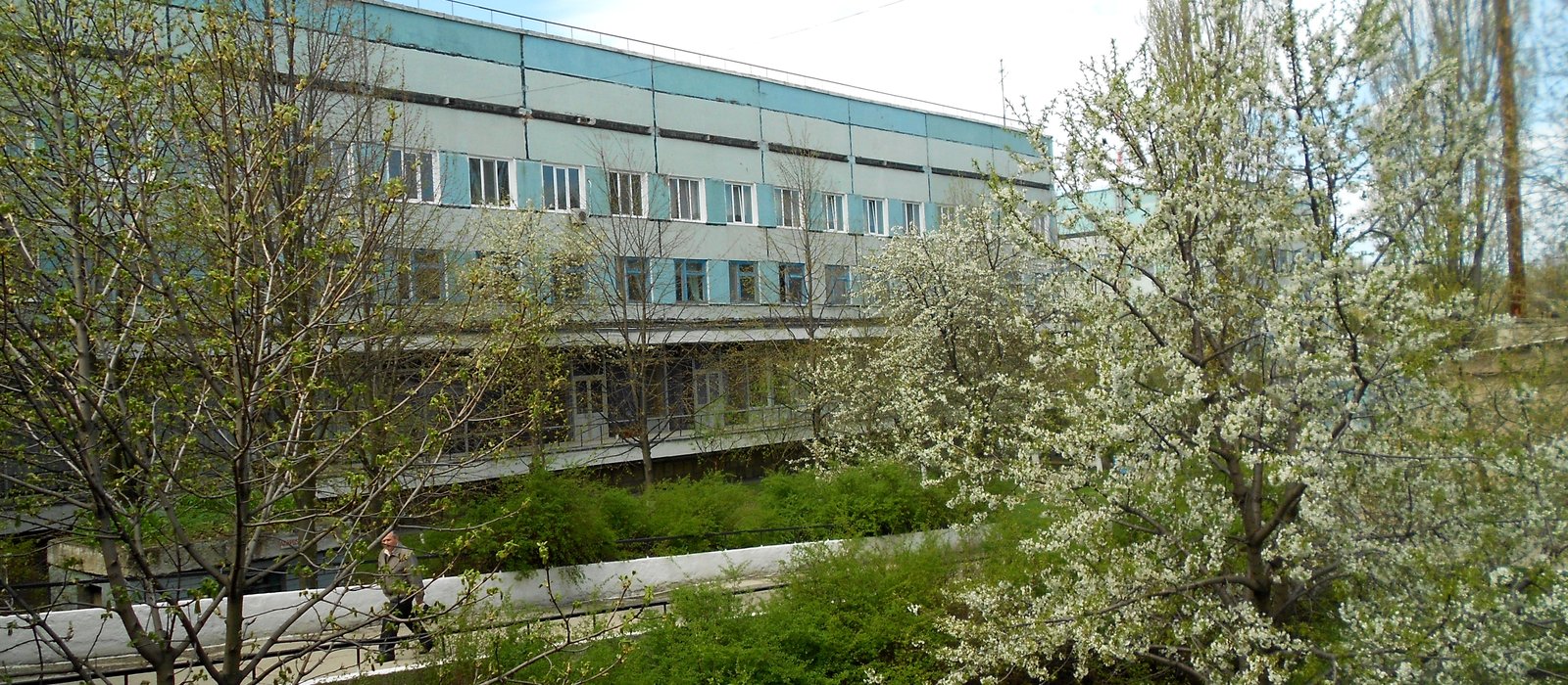 Clădirea Spitalului Clinic Municipal din Bălți, printre pomi înfloriți, într-o zi de primăvară