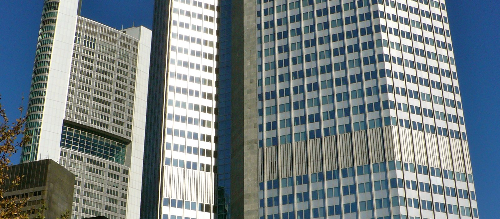 Turnul Eurotower din Frankfurt, fostul sediu al BCE, văzut de jos, cu fațada de sticlă și cerul senin