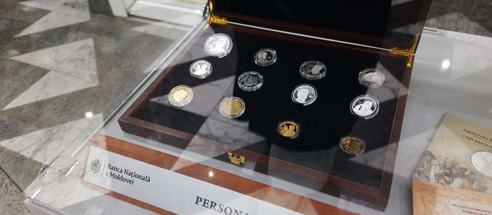 Monede comemorative din argint și aur într-o cutie de lemn, în expoziția Băncii Naționale a Moldovei