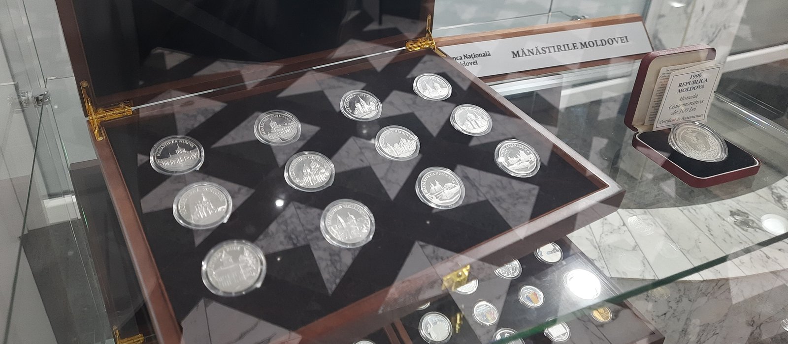 Vitrine cu monede comemorative în holul Băncii Naționale a Moldovei, seria Mănăstirile Moldovei