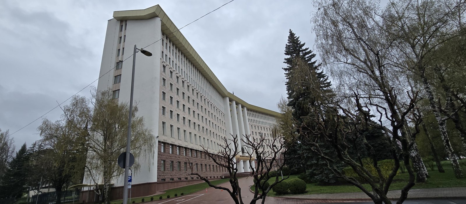 Clădirea Parlamentului Republicii Moldova din Chișinău, văzută din parcul din fața intrării, sub un cer acoperit