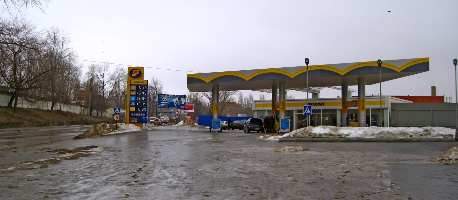 Stație de alimentare Petrom în sectorul Ciocana din Chișinău, iarna, cu panoul de prețuri lângă drum
