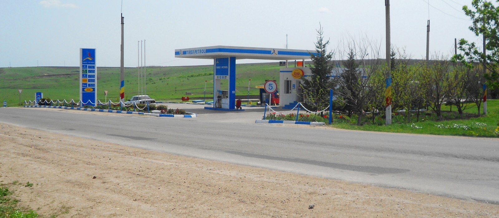Stație de alimentare lângă un drum național din Moldova, cu un panou de prețuri și o singură pompă sub copertină