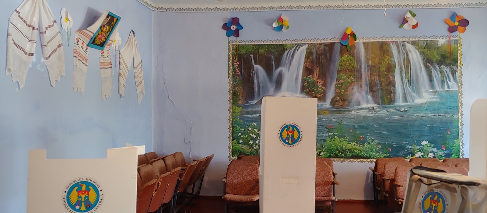 Secție de votare într-o sală dintr-un sat din Republica Moldova, cu urne și mese pentru comisia electorală
