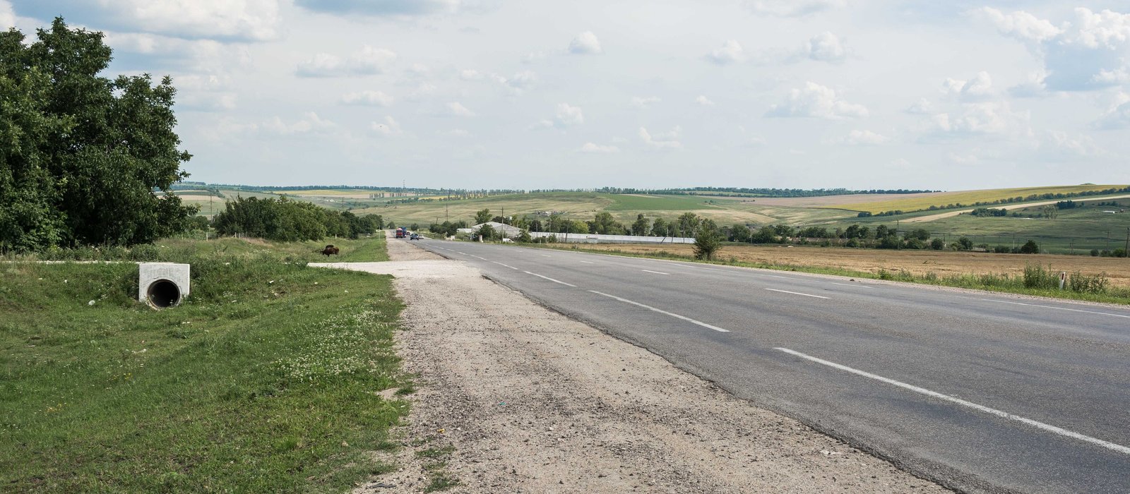 Drumul național M14 într-o zi cu cer senin, asfalt cu două benzi și câmpuri de ambele părți