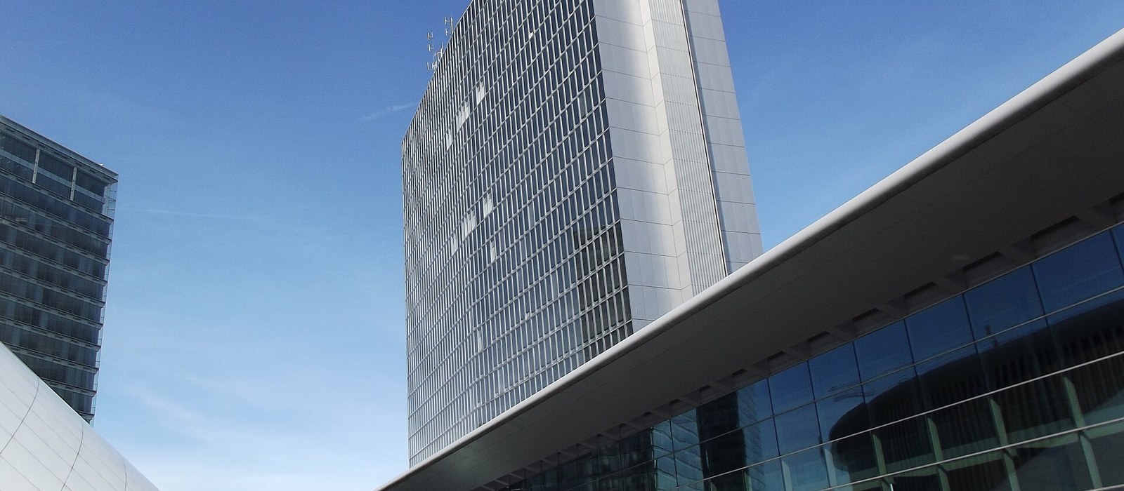 Centrul European de Conferințe din Luxemburg, văzut de jos, cu un turn de sticlă în spate