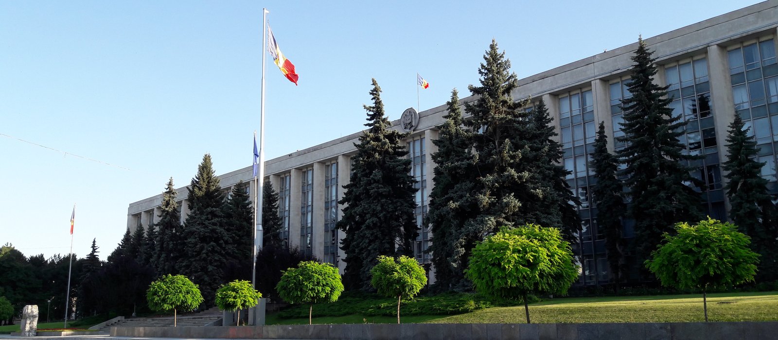 Clădirea Guvernului Republicii Moldova din Chișinău, cu drapelele în fața fațadei