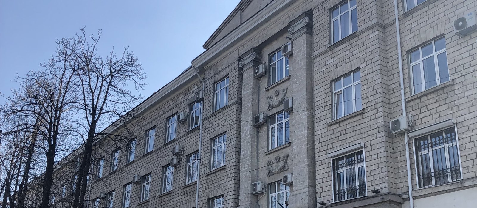 Fațada clădirii Ministerului Finanțelor din Chișinău, cu ferestre în rânduri și un copac fără frunze în față
