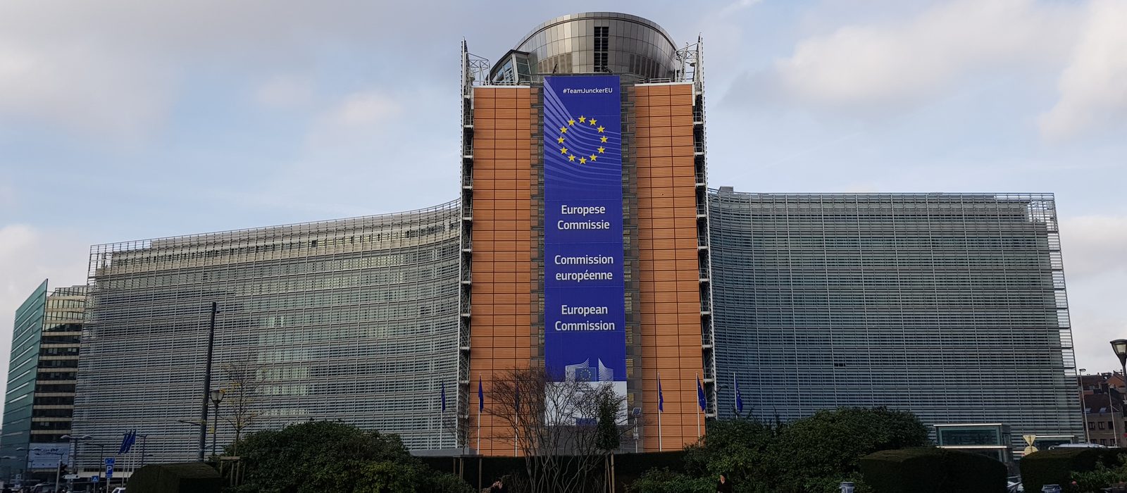 Fațada clădirii Berlaymont din Bruxelles, sediul Comisiei Europene, cu un banner albastru mare cu steagul UE