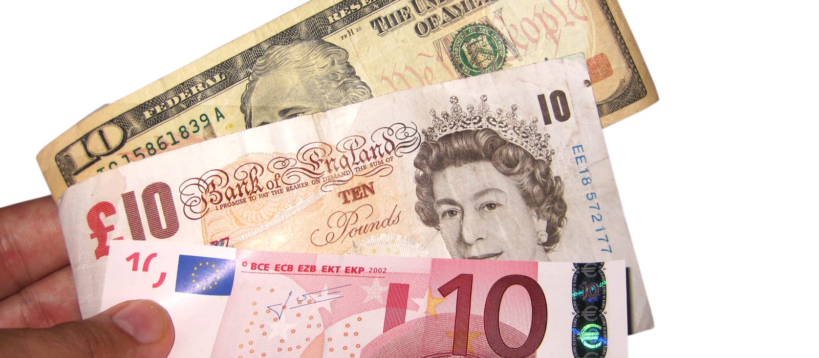 O mână ține în evantai o bancnotă de 10 dolari, una de 10 lire sterline și una de 10 euro, pe fond alb