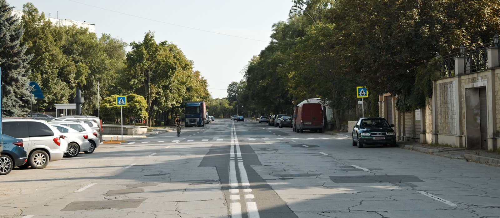 Stradă cu clădiri și copaci în centrul Chișinăului, într-o zi însorită