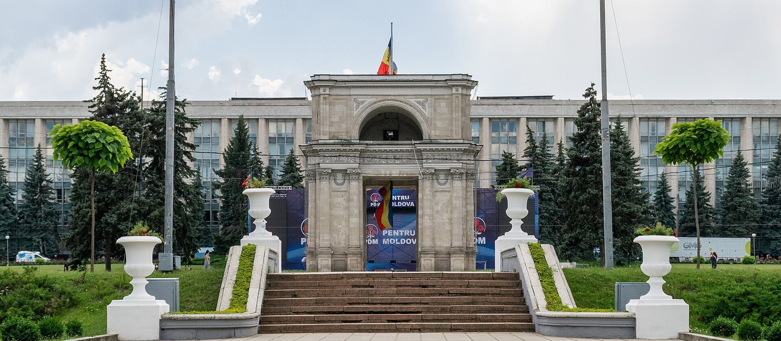 Clădirea Guvernului Republicii Moldova din Chișinău, cu fațada înaltă de sticlă și beton, văzută de la nivelul străzii