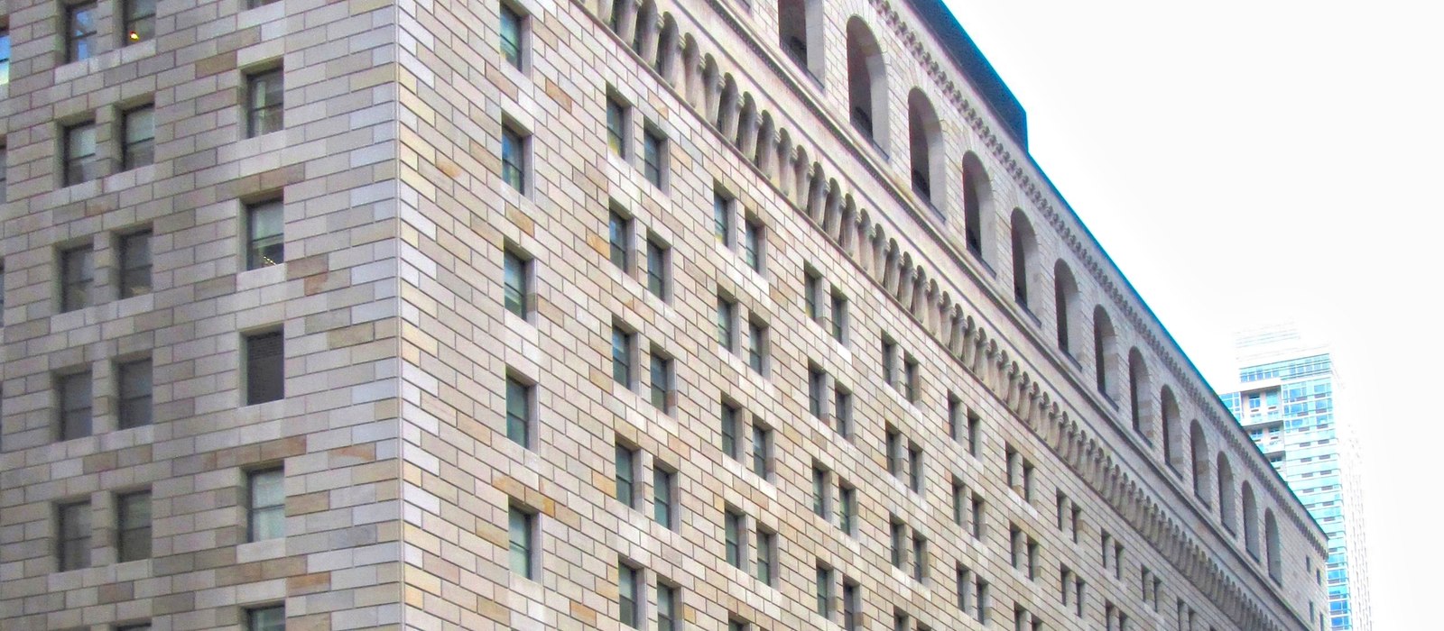 Fațada clădirii Federal Reserve Bank of New York, cu ferestre mici și arcade din piatră