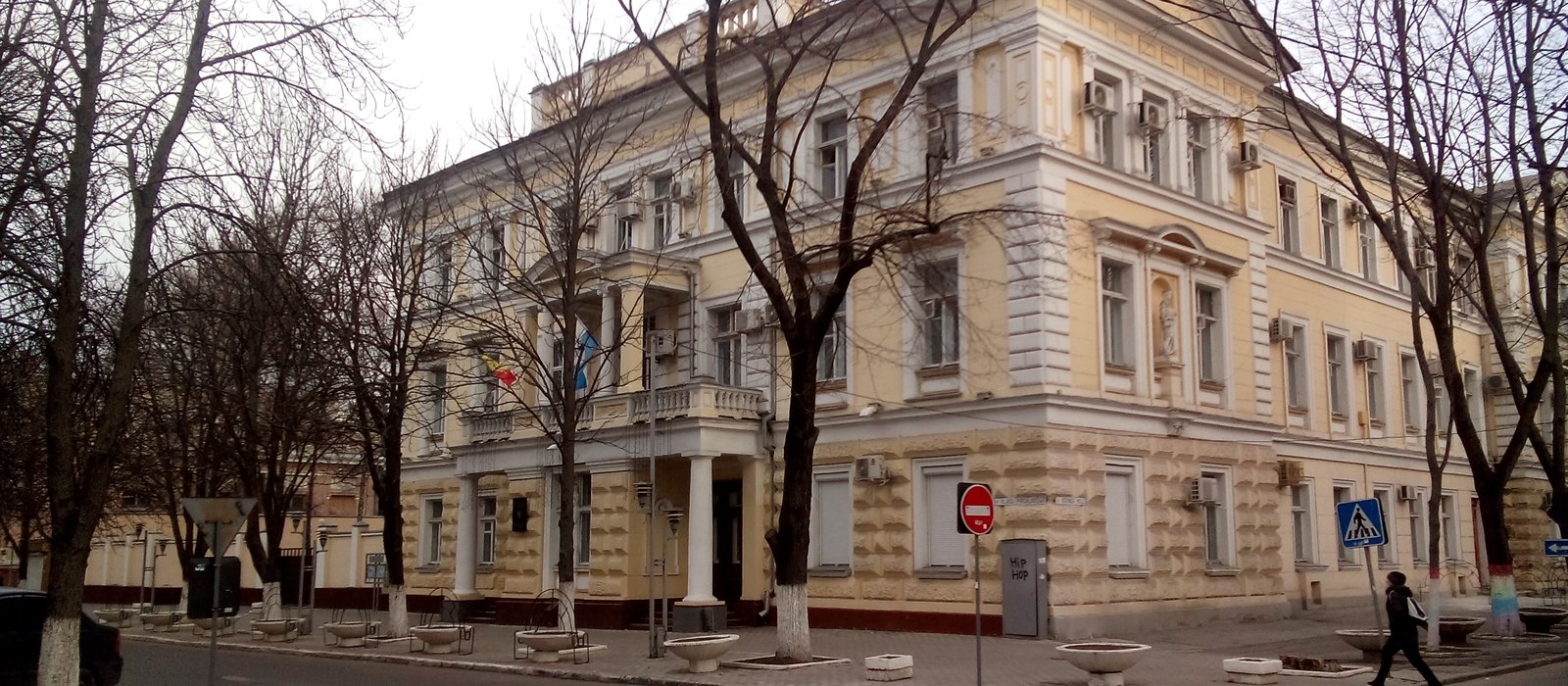 Clădirea istorică, în două etaje cu coloane, a fostei judecătorii de district din Chișinău, iarna, cu copaci fără frunze