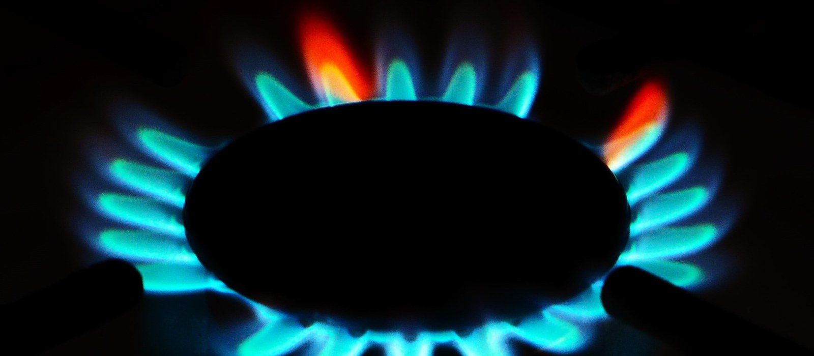 Flăcări albastre la arzătorul unei plite pe gaz, văzute de aproape