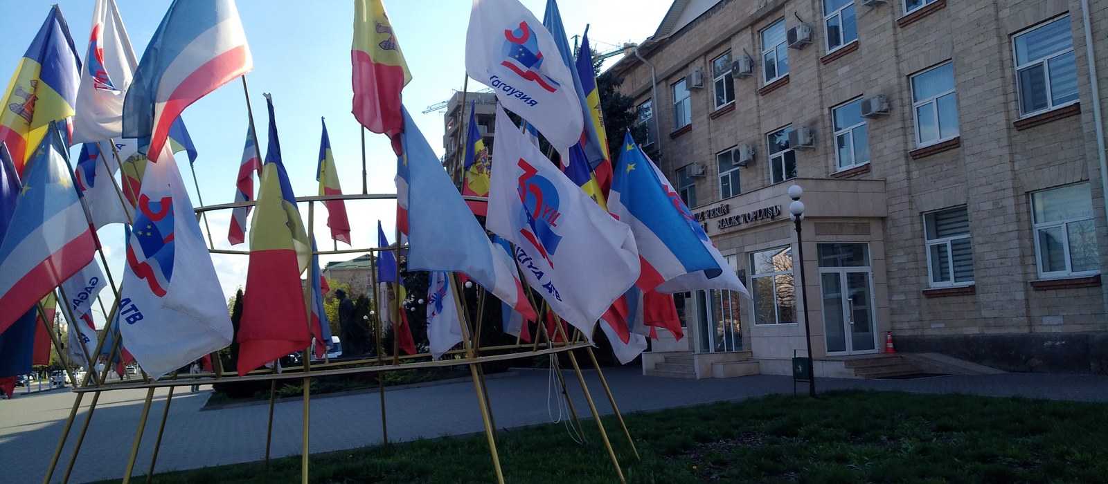 Drapelul Republicii Moldova și drapelul Găgăuziei fluturând alături, pe cer senin