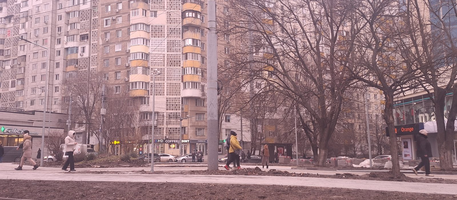 Blocuri de locuințe cu balcoane și trecători pe o stradă din Chișinău, iarna