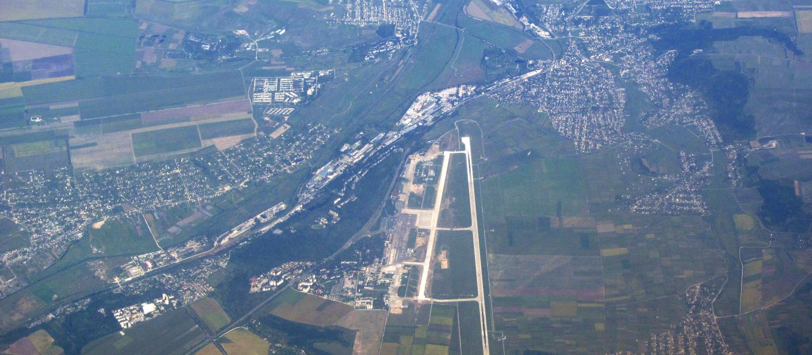 Aeroportul Internațional Chișinău văzut de sus, cu clădirea terminalului și pista