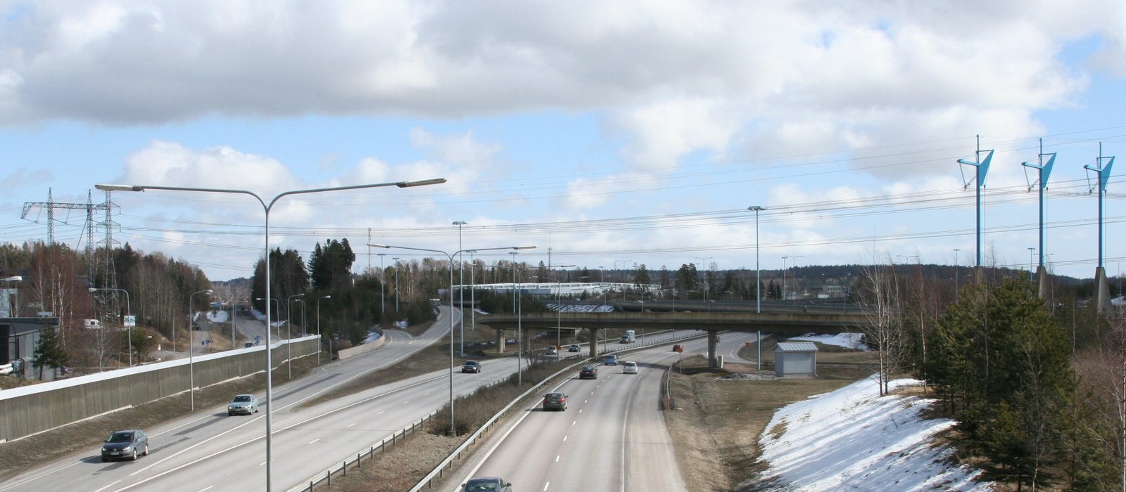 Linie electrică aeriană de 400 kV pe stâlpi metalici, lângă o autostradă, în Espoo, Finlanda (imagine ilustrativă)