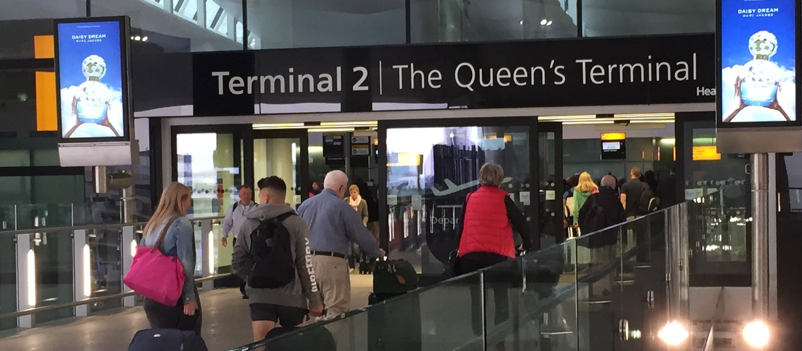 Intrarea în sala de plecări a Terminalului 2 de la Heathrow, cu pasageri cu bagaje