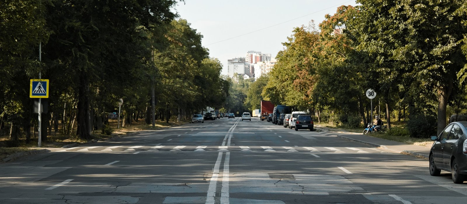 Stradă din centrul Chișinăului cu clădiri și trafic ușor