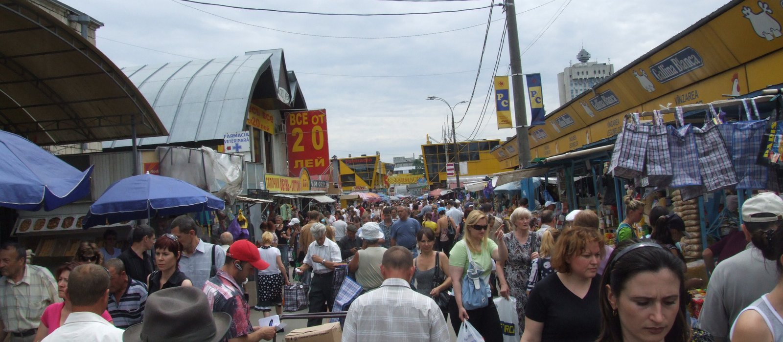 Tarabe și cumpărători la Piața Centrală din Chișinău, cu firme mici care vând produse sub corturi