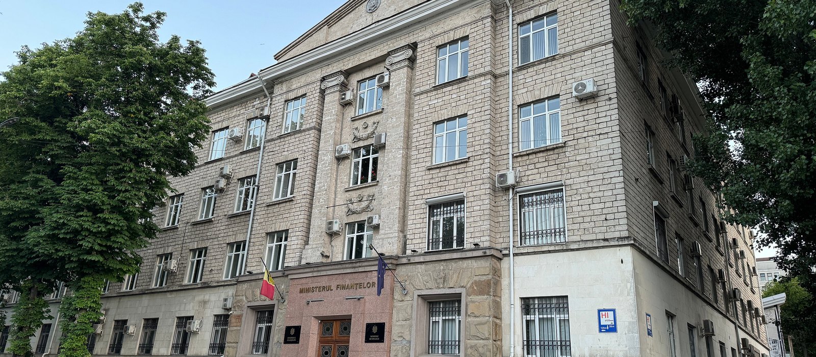 Clădirea Ministerului Finanțelor din Chișinău, cu intrarea din granit roșu și drapelele Moldovei și Uniunii Europene