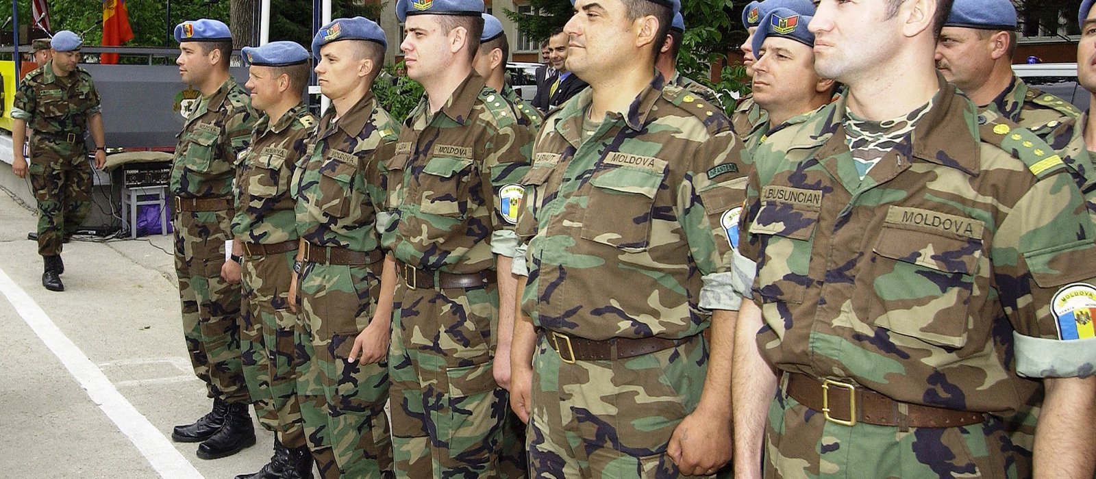 Militari moldoveni aliniați în uniformă de câmp și beretă albastră, în timpul unei ceremonii