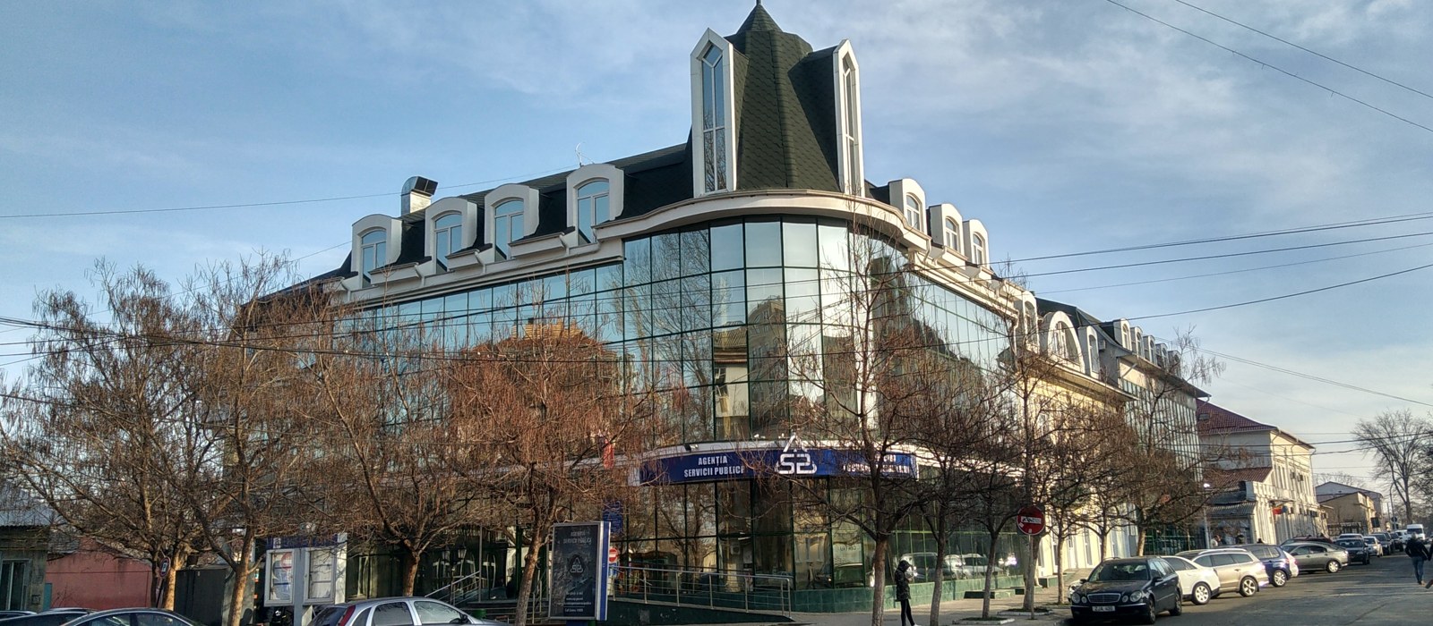 Clădirea Agenției Servicii Publice din Chișinău, cu fațada gri și vitrate, văzută din stradă