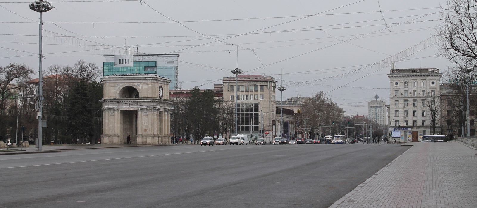 Bulevard larg din centrul Chișinăului, cu Arcul de Triumf în stânga și clădiri administrative în fundal