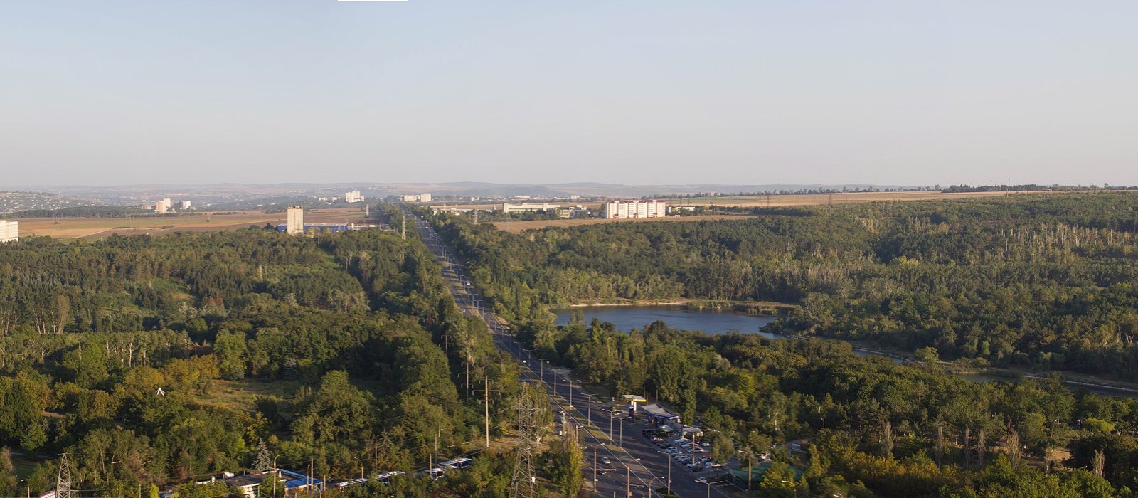 Priveliște panoramică asupra Chișinăului, cu blocuri, străzi și zone verzi, văzută de sus