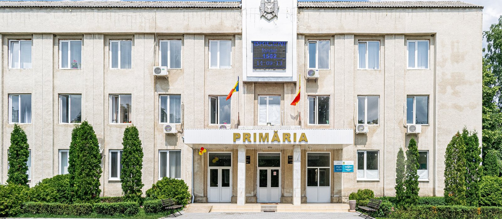 Clădirea primăriei din Briceni, cu stema și drapelele la intrare