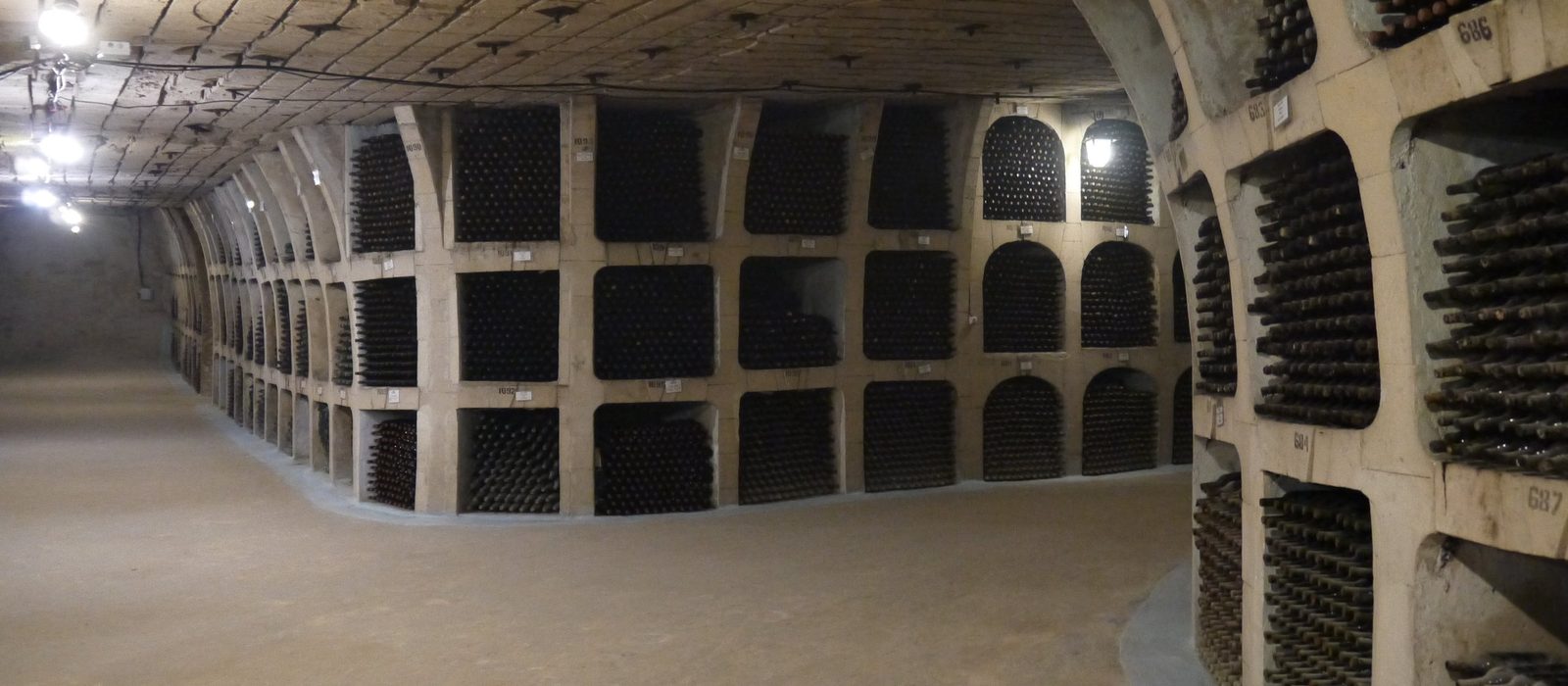 Coridor din cramele de la Mileștii Mici, cu nișe de piatră pline de sticle de vin