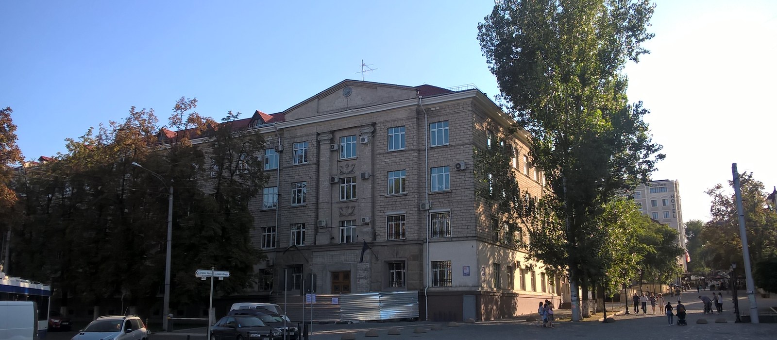 Clădire de epocă socialistă cu patru etaje pe bulevardul Grigore Vieru din Chișinău, cu copaci în față