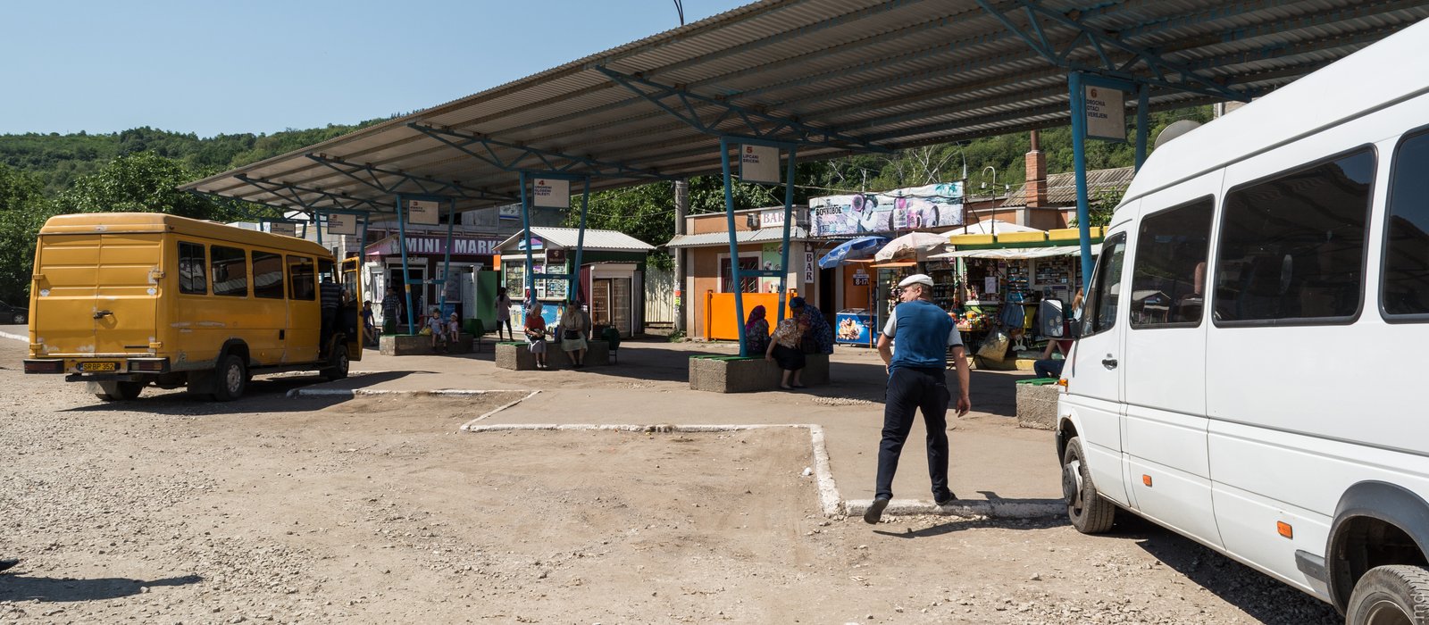 Microbuze galbene și albe în stația autogării din Soroca, cu pasageri sub acoperișul peroanelor