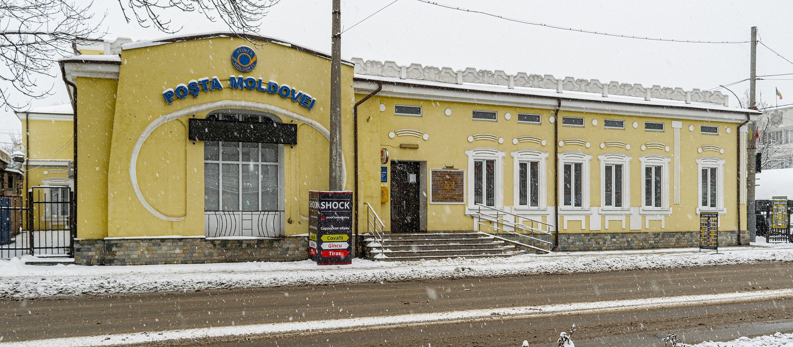 Clădirea galbenă a oficiului central al Poștii Moldovei din Bălți, într-o zi cu ninsoare