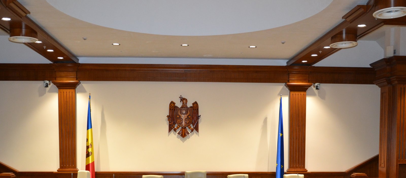 Sala de ședințe a Parlamentului Republicii Moldova, cu drapelele Moldovei și Uniunii Europene lângă stema de stat