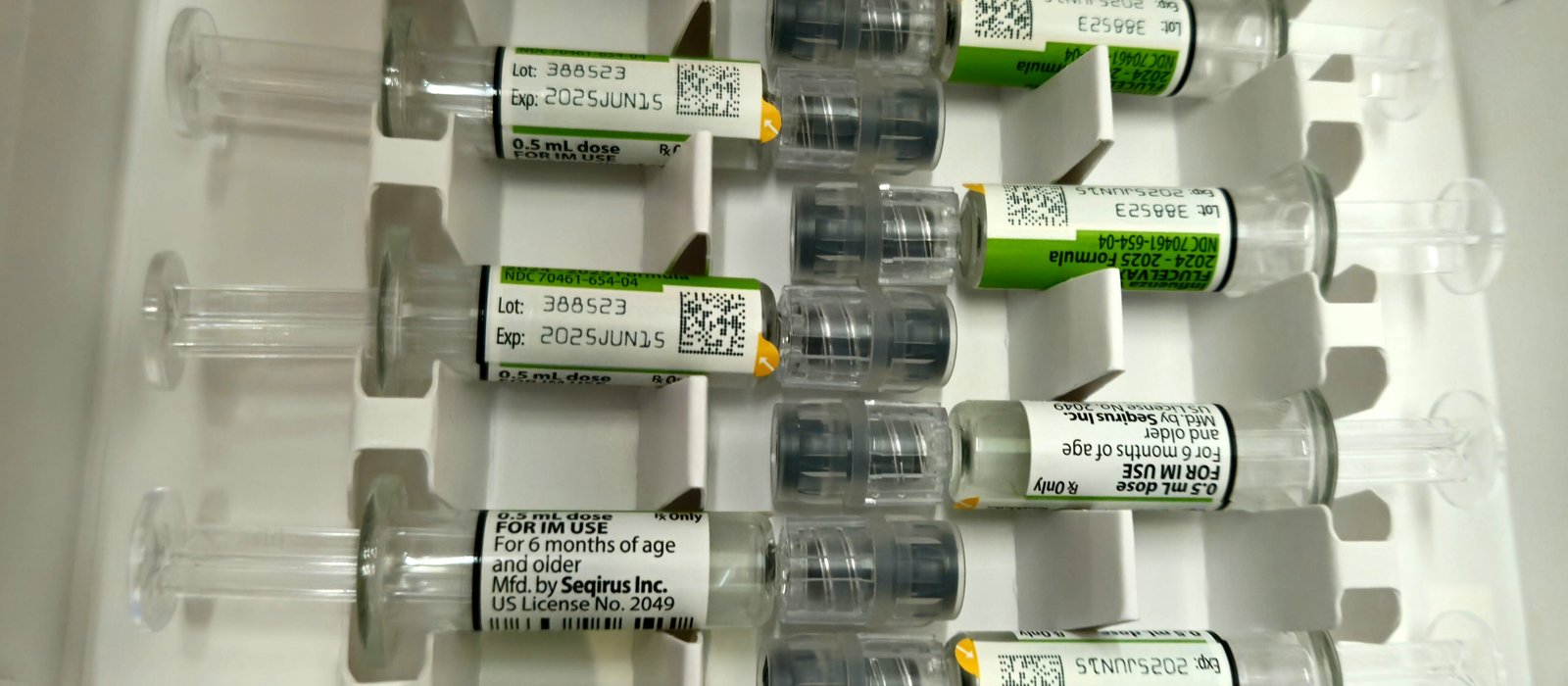 Seringi preumplute cu vaccin antigripal, așezate pe o masă