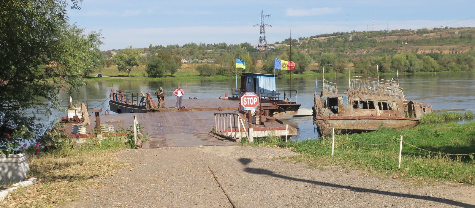 Bacul de pe Nistru la un punct de trecere a frontierei dintre Moldova și Ucraina, lângă Soroca, cu drapelele celor două țări